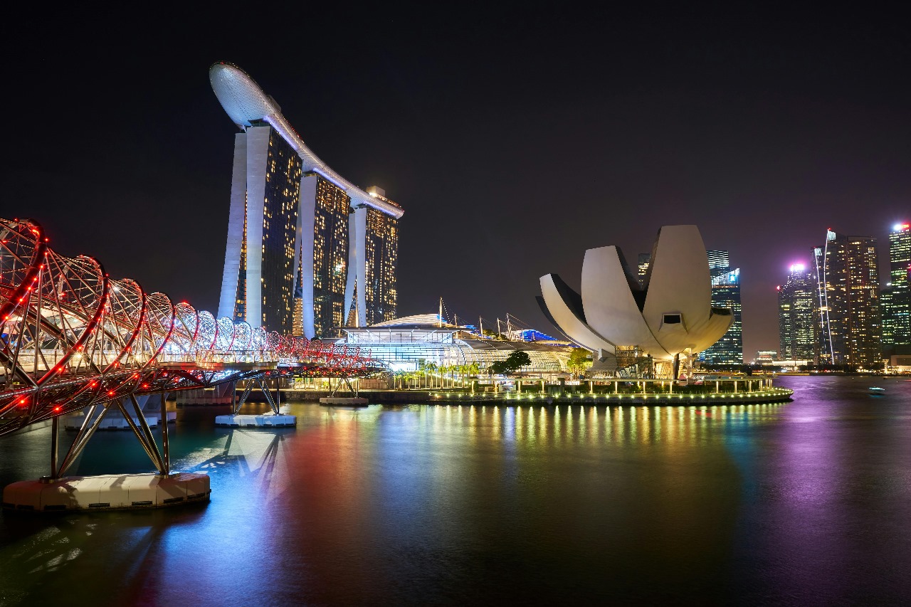 Singapore's Marina Bay Sands, Helix Bridge, and ArtScience Museum illuminated at night, showcasing the city-state's modern architecture and world-class education hub status