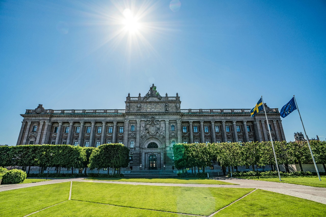 Swedish Parliament building in Stockholm with Swedish and EU flags, showcasing Sweden's democratic values and world-class education system